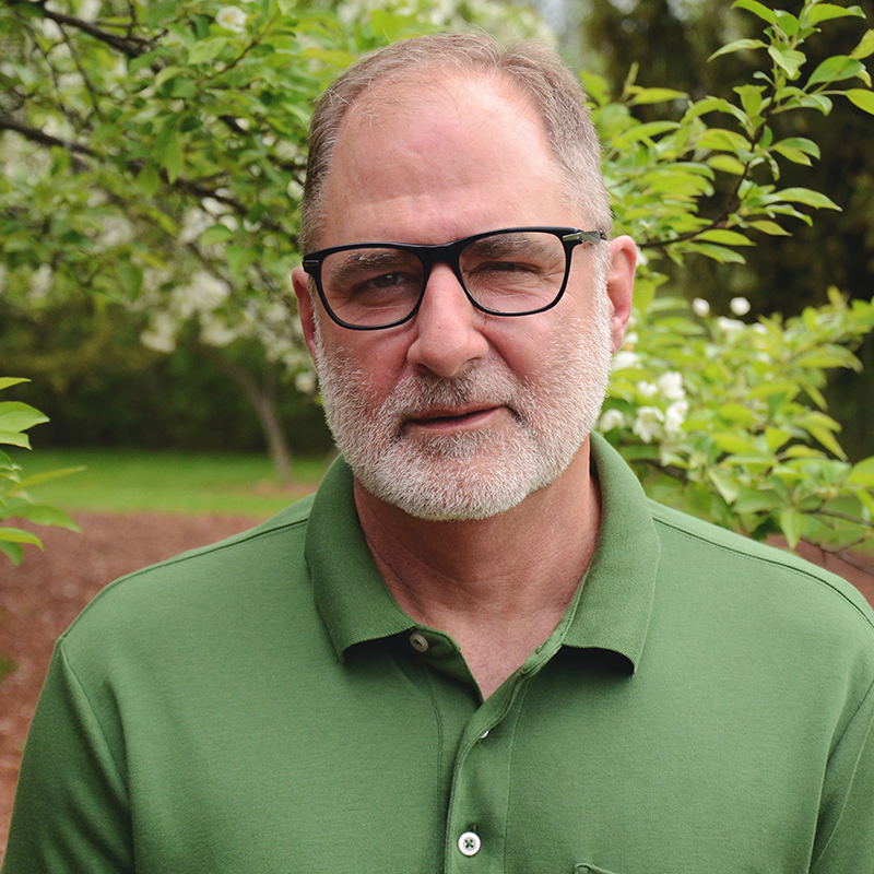 Older Male Pulmonologist with Dark Glasses and Green Polo Shirt